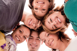 group of happy teenagers in circle  view from below